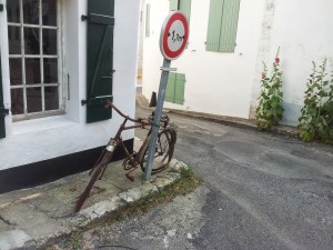 Sur l'île de Ré, un vélo rouille depuis quelques années autour de son panneau...