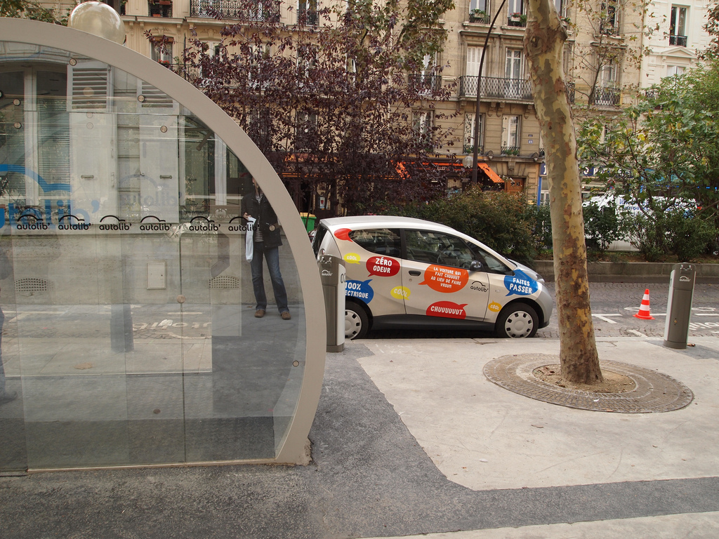 Un véhicule Bluecar de Blue Solutions (groupe Bolloré) du service d'autopartage en "trace directe" Autolib en région parisienne garé près d'une station permettant les inscriptions à distance (photos par Francisco Gonzalez diffusée sur Flickr sous licence Creative Commons 2.5 - http://creativecommons.org/licenses/by/2.5/)